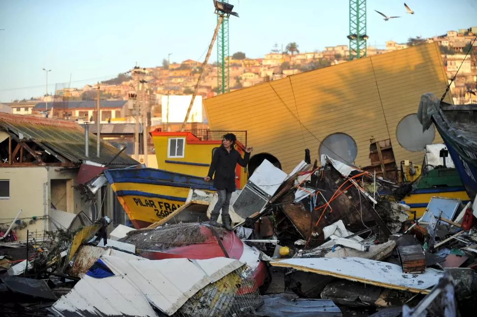 DEVASTACIÓN. Una vecina de la ciudad de Coquimbo observa desesperada cómo el terremoto redujo a escombros algunos sectores de su barrio. Reuters.