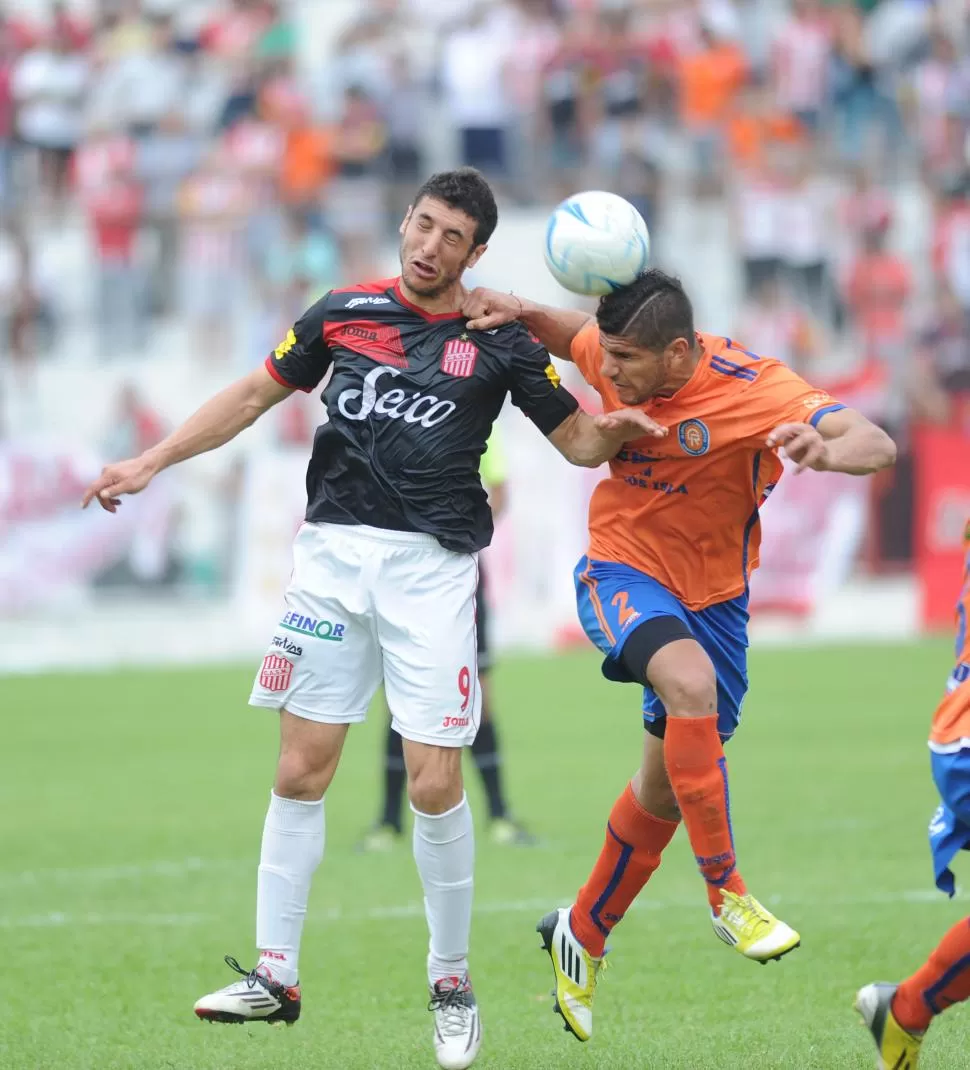 LUCHA CUERPO A CUERPO. Iván Agudiak pelea en lo alto con el defensor Mauro Martínez. El delantero de San Martín tuvo chances para marcar, aunque no estuvo fino en la definición frente a Deportivo Roca. la gaceta / foto de héctor peralta