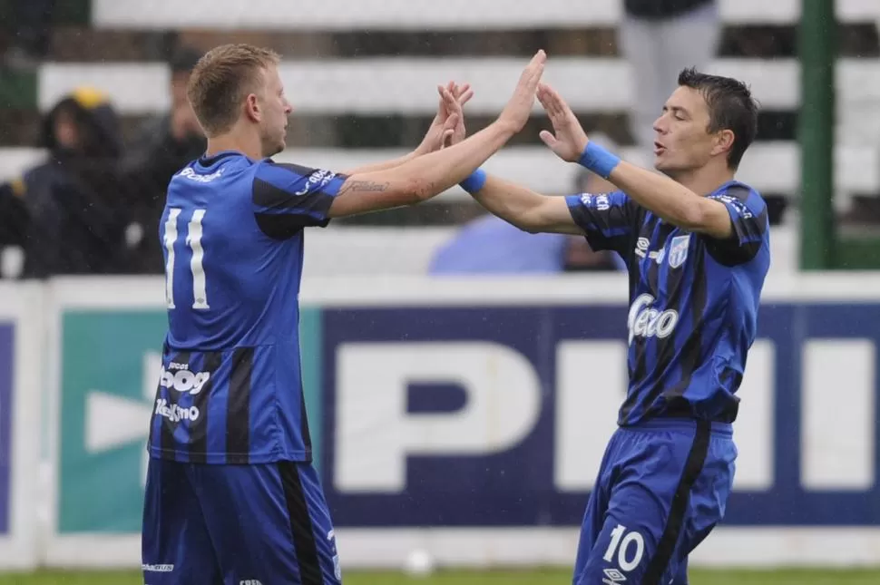 SALUDO DE GOL. Menéndez (11) choca manos con González, que marcó el único tanto de Atlético en casa de Estudiantes, en San Luis. “LG” casi anota un doblete, pero su remate se estrelló en el travesaño. aip foto / Andres Larrovere (ESPECIAL PARA LA GACETA)