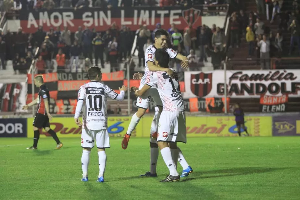 SALUDO DE GOLEADORES. Comas (9) y Quiroga (17), que aportaron una conquista y dos, respectivamente, festejan el doblete del gigante de Patronato, que será papá. foto del diario “uno” de entre rios