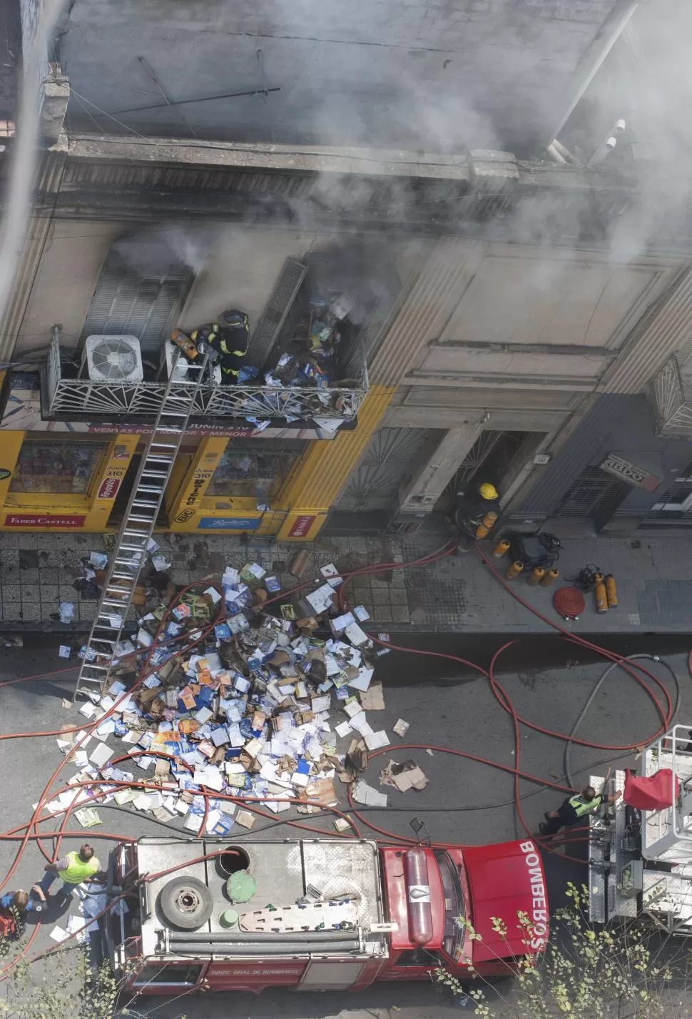 A LA CALLE. Los bomberos sacaron parte de la mercadería a la calle para evitar que siga alimentando a las llamas. la gaceta / foto de florencia zurita