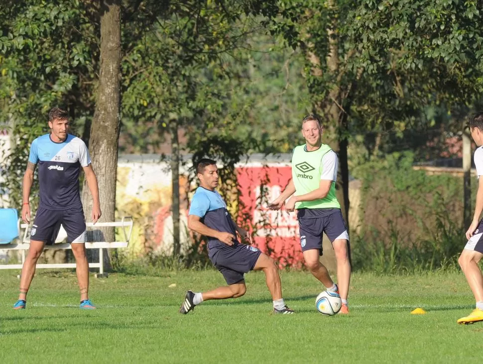 DOS DE TRES. Sbuttoni observa cómo Menéndez se desprende de la pelota ante la marca de Acosta, durante un entrenamiento en Ojo de Agua. Ni el defensor ni el volante estarán presentes el domingo.  la gaceta / foto de héctor peralta