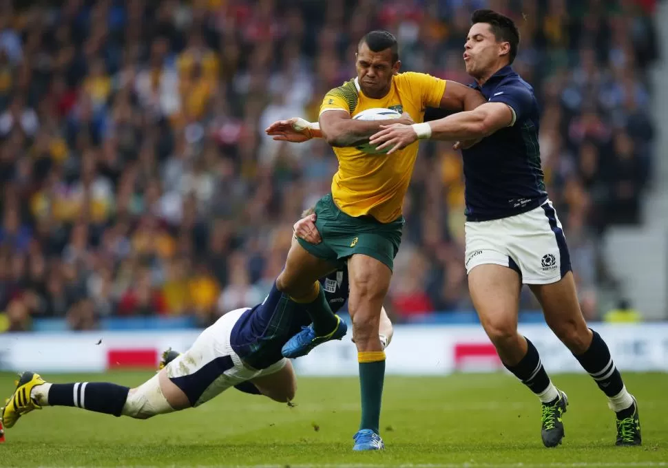 CON TODA LA POTENCIA. Los escoceses Finn Russell y Sean Maitland intentan frenar al potente australiano Kurtley Beale, una de las figuras de los “wallabies”. REUTERS