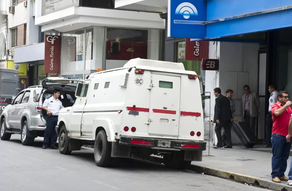 EN SAN MARTÍN AL 700. Un empleado de Tesorería de la Legislatura retira una valija del banco, en octubre. Abordará la camioneta con baúl abierto. la gaceta / foto de jorge olmos sgrosso