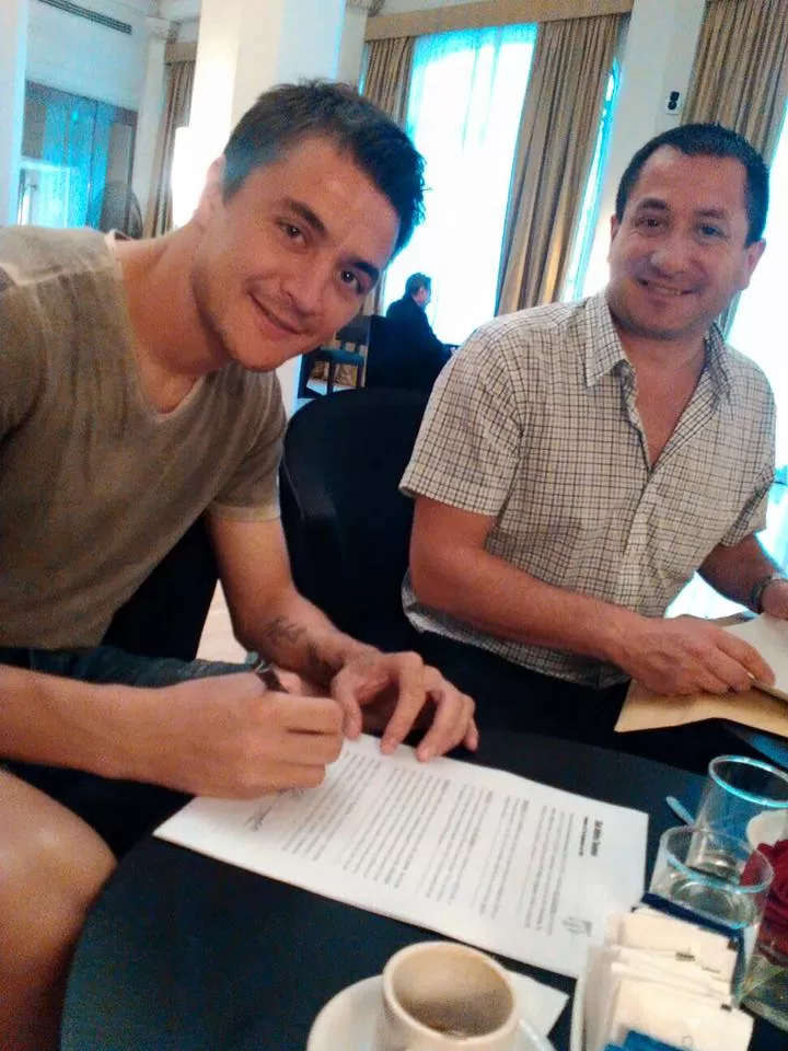 EL MOMENTO JUSTO. Leandro González junto a Hugo Cervantes (representante “decano” en AFA), poniendo la firma.   facebook.com/leandrog20