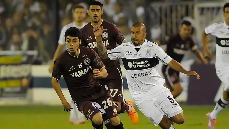 FESTEJÓ EL GRANATE. Almirón, que fue expulsado, es marcado por Brum, de Gimnasia.
FOTO DE DYN