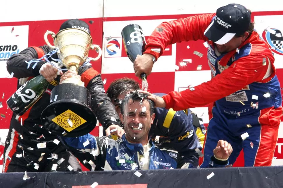 TRIUNFALES. Mohamed le tira champán a Percaz que recibió la copa de campeón. Prensa Mohamed Competición 