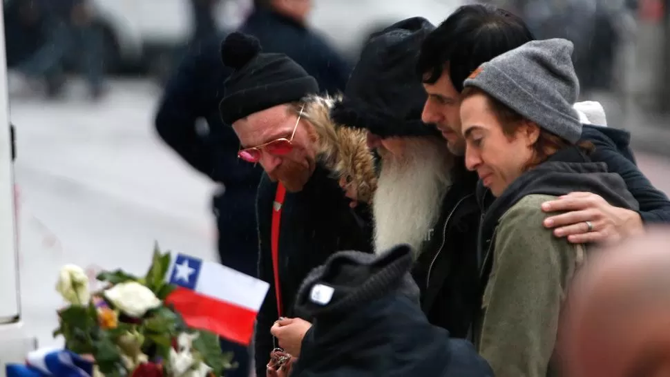 DE LUTO. La banda se acercó al Bataclan para dejar flores en honor a los muertos. REUTERS