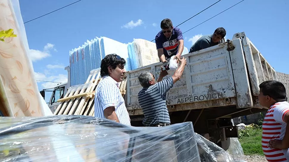 EN LAS TALITAS. Los daminificados por las inundaciones recibieron colchones. FOTO TOMADA DE COMUNICACIONTUCUMAN,GOB.AR