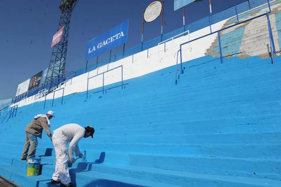 CON TODO. Dos empleados del club pasan los rodillos por las escalinatas de las tribunas del Monumental. El estadio lucirá una nueva apariencia.  la gaceta / foto de héctor peralta