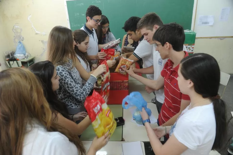 -“UNA NOCHEBUENA PARA TODOS”. Chicos del colegio Nueva Concepción arman cajas con productos navideños para los más necesitados. LA GACETA / FOTOS DE ANTONIO FERRONI. 