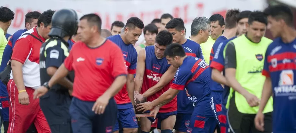 LAMENTABLE. El golero Germán Montenegro es trasladado por auxiliares de su equipo hacia el vestuario visitante luego de sufrir el estallido de un elemento de pirotecnia que le lanzaron desde la tribuna. LA GACETA / FOTOS DE DIEGO ARÁOZ