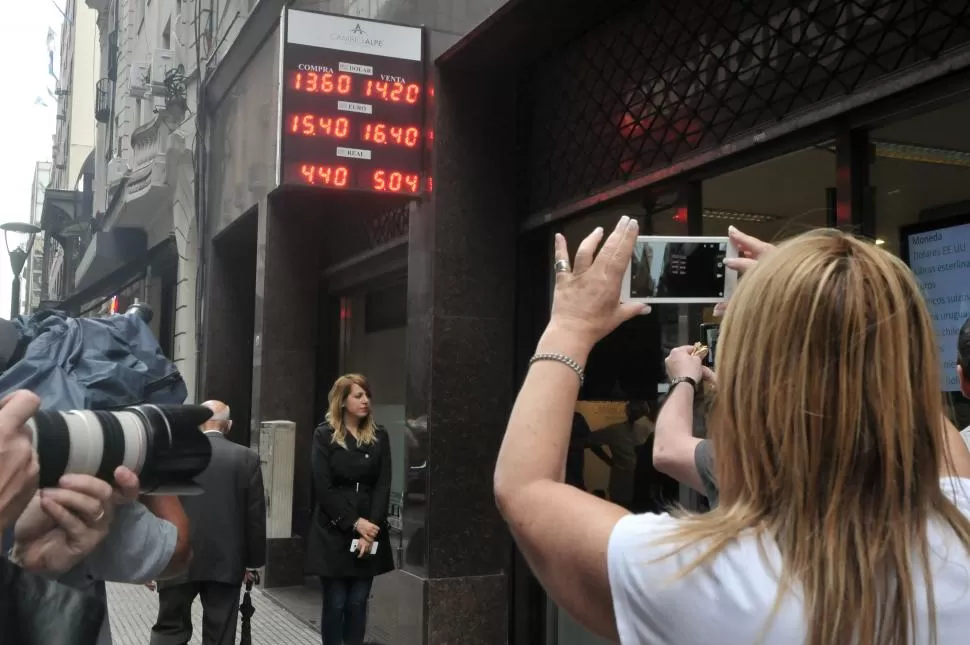 INTERÉS PERIODÍSTICO. Pizarras y letreros de los bancos y agencias de cambio fueron otra vez bombardeadas por los flashes para retratar el valor del dólar. telam