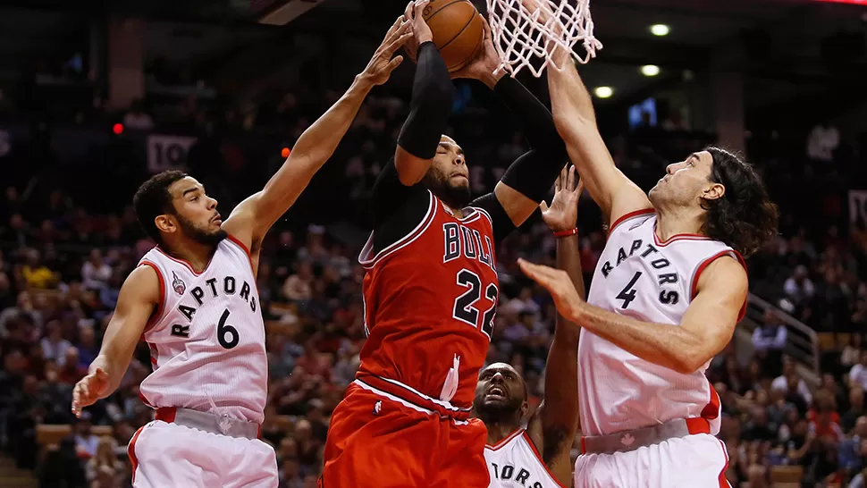 DERROTA AJUSTADA. Scola, junto a Joseph y Paterson, intentan evitar la conversión de Taj Gibson, de los Bulls.
FOTO DE REUTERS