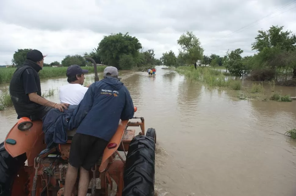 SIN ASISTENCIA SOCIAL. El cauce del río Medina cubrió ayer toda la ruta 331 y los pobladores de Los Agudo debieron transitarla en tractores. la gaceta / fotos de florencia zurita