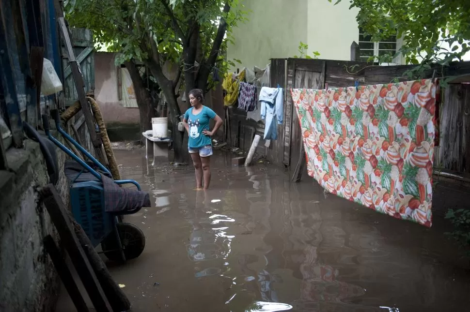 IMPOTENCIA. Una vecina del barrio 2 de Abril contempla con resignación el avance de las aguas del canal Sur en el patio de su casa.  