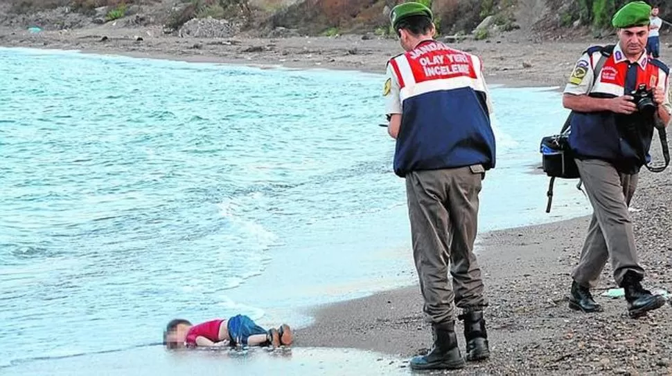 EL 2 DE SEPTIEMBRE DE 2015. Un agente de policía se acerca a levantar el cuerpo del niño que murió ahogado. reuters 