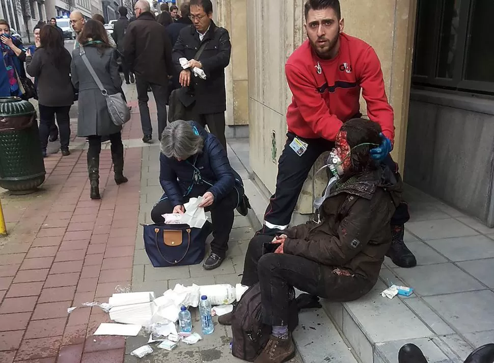 EN LA CALLE. Una mujer es socorrida fuera del subterráneo. credito