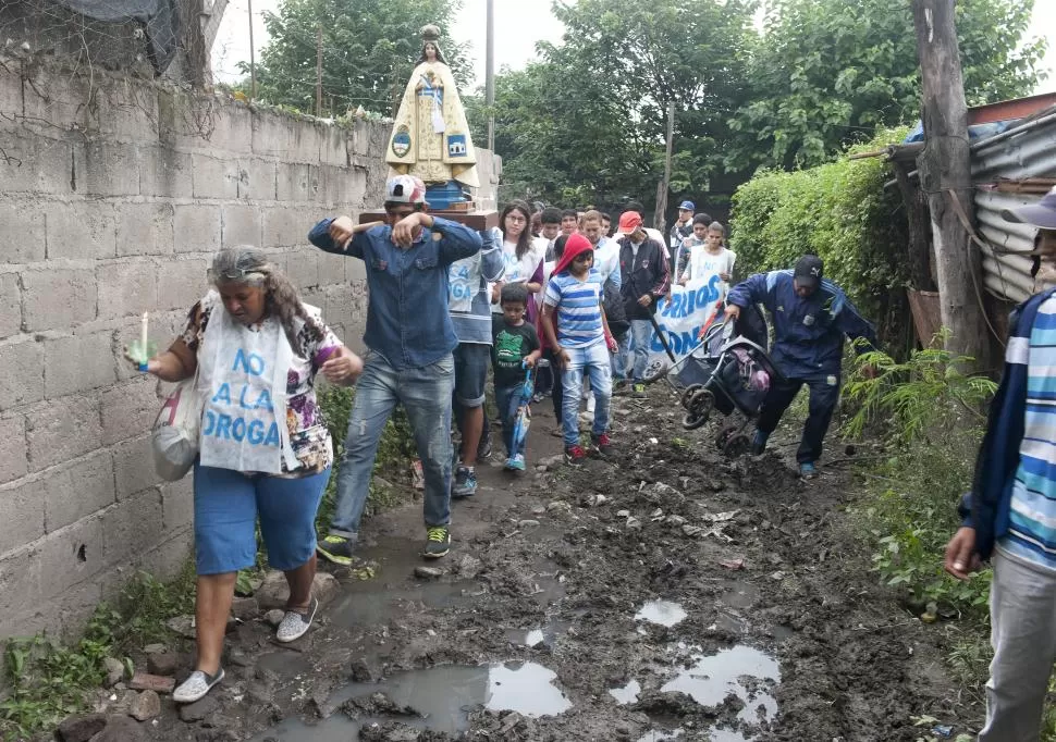 BASURAL. La procesión, con más de cien personas, pasa por una barranca del Río Salí, sorteando desperdicios.  la gaceta / fotos de florencia zurita 