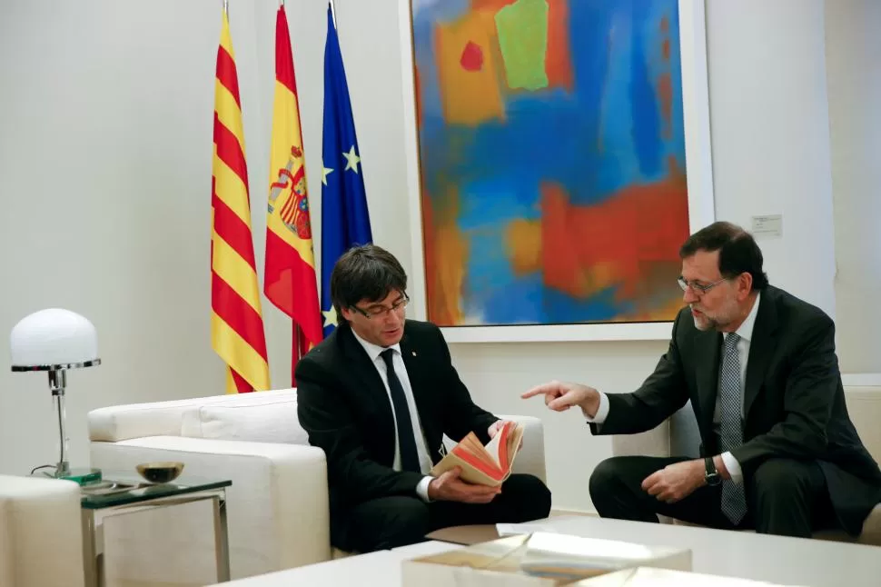 PROTOCOLO. Rajoy le obsequió a Puigdemont un facsímil de “El Quijote”. reuters 