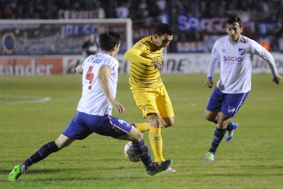 ÁSPERO DUELO. Tevez intenta superar la férrea marca de Fucile. El lateral uruguayo corrió y metió como todo su equipo; “Carlitos” y compañía, hicieron lo que pudieron. télam