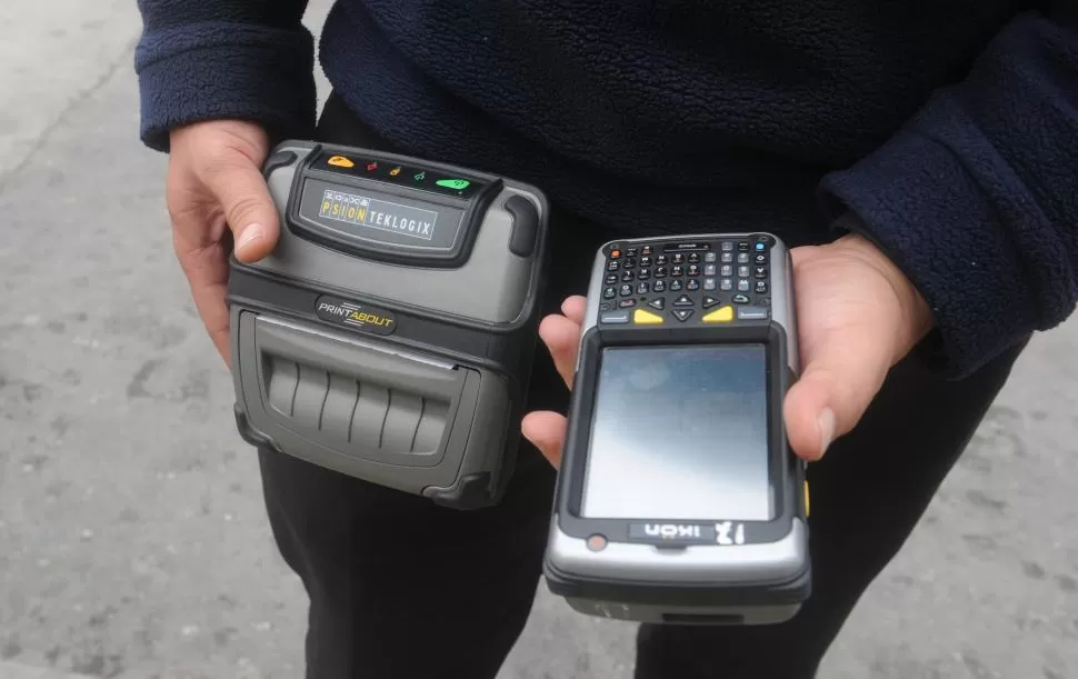 EQUIPO. Un inspector de Tránsito muestra su Asistente Personal Digital (a la derecha de la foto) y la impresora. LA GACETA / FOTO DE ANTONIO FERRONI.