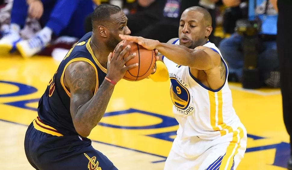 FIGURA. Iguodala, una de las figuras de Warriors, defiende ante un ataque de James. REUTERS