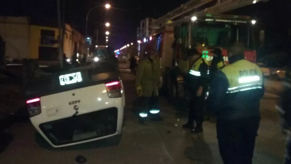 Un taxi chocó dos autos estacionados y terminó volcado