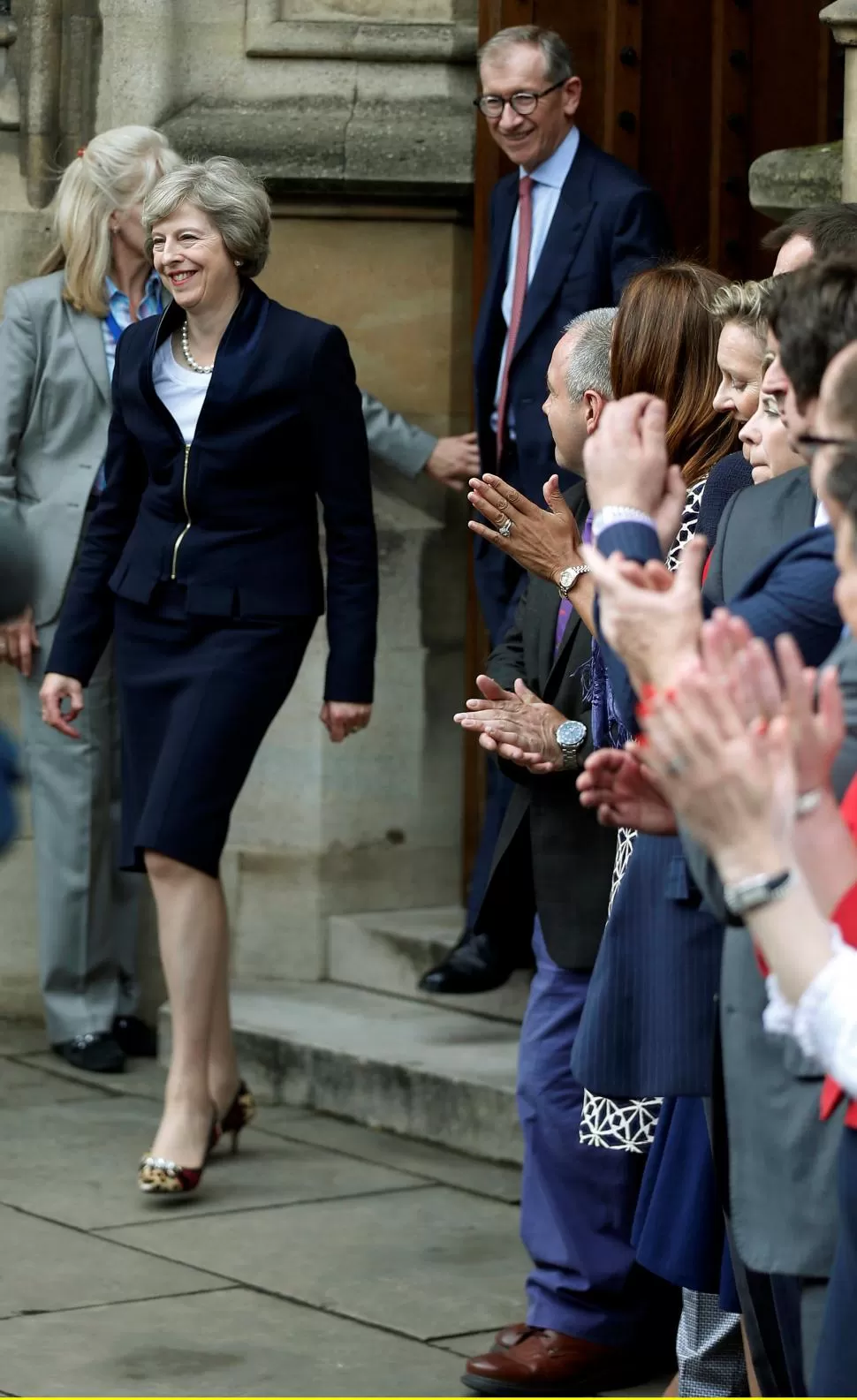 FANÁTICA DE LOS ZAPATOS. Detrás de May aparece su esposo. reuters 