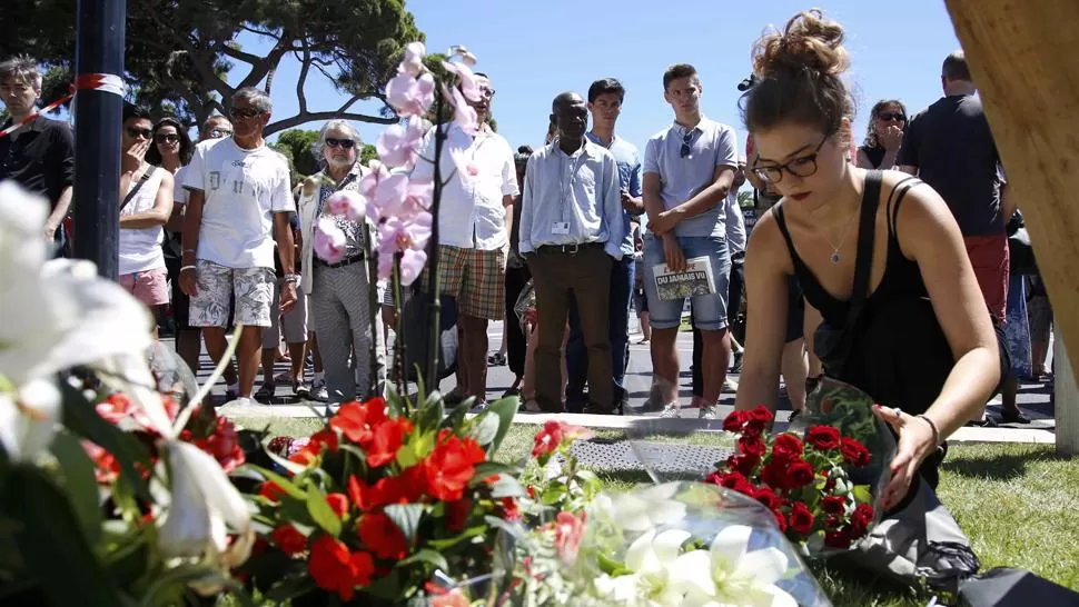 LUTO. Una mujer deja flores en el lugar del atentado. REUTERS