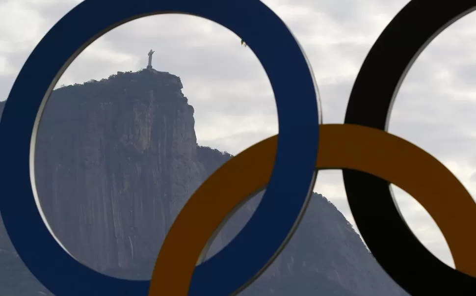 UNA SÍNTESIS. El Cristo del Corcovado se ve a la distancia, enmarcado por los tradicionales anillos olímpicos. fotos REUTERS