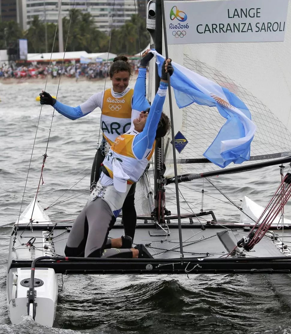 A FESTEJAR. Lange mira al cielo y y sonríe. Su compañera, Cecilia Carranza, 25 años menor que él, se acerca para fundirse en un abrazo histórico para la vela argentina. REUTERS