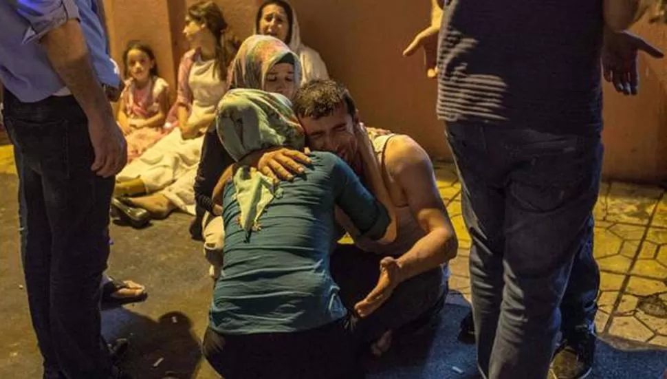 ATENTADO. Familiares sufren las pérdidas. FOTO TOMADA DE CLARÍN.