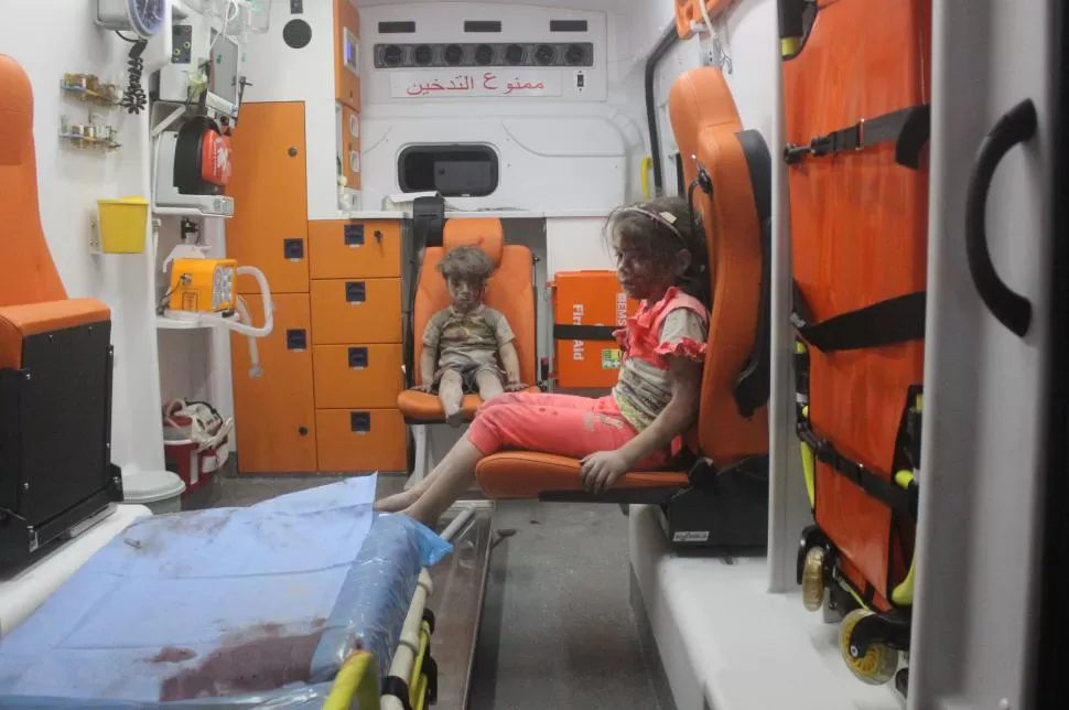 DRAMA Y DOLOR. Omran y una niña son trasladados hacia el hospital donde lo atendieron y curaron sus heridas. Su casa fue destruida por un bombardeo REUTERS