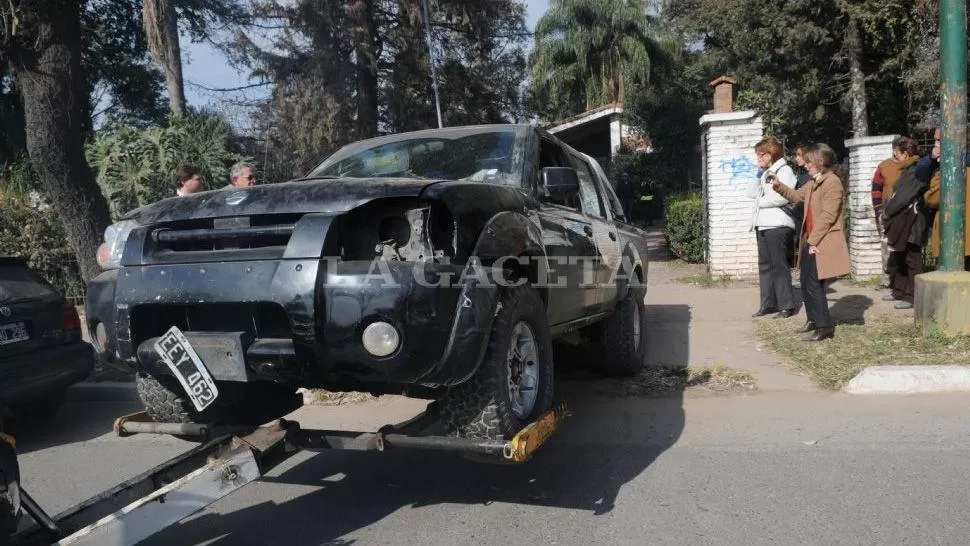 INDICIOS DE UN IMPACTO. La camioneta negra tiene dañada la trompa y manchas de sangre. Familiares de Pucheta observan el procedimiento.