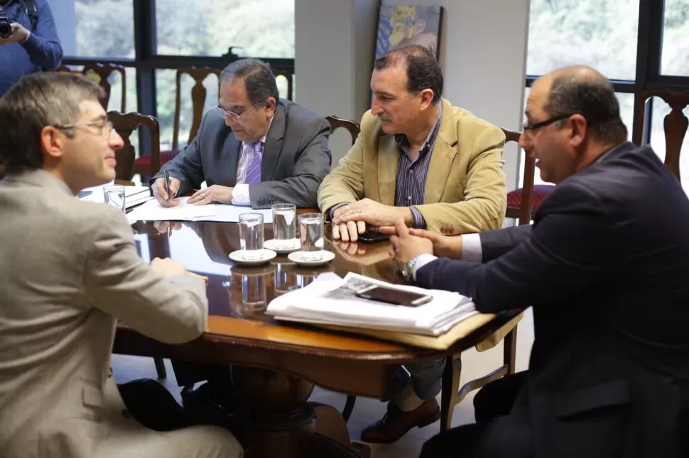 TODOS DE ACUERDO. Caponio habla desde la cabecera, mientras Canelada lo observa. Bourlé firma el dictamen, ante la mirada de Morghenstein. prensa legislatura