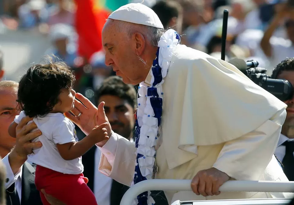 EL VATICANO. Francisco acaricia a un niño, durante un acto con voluntarios. reuters