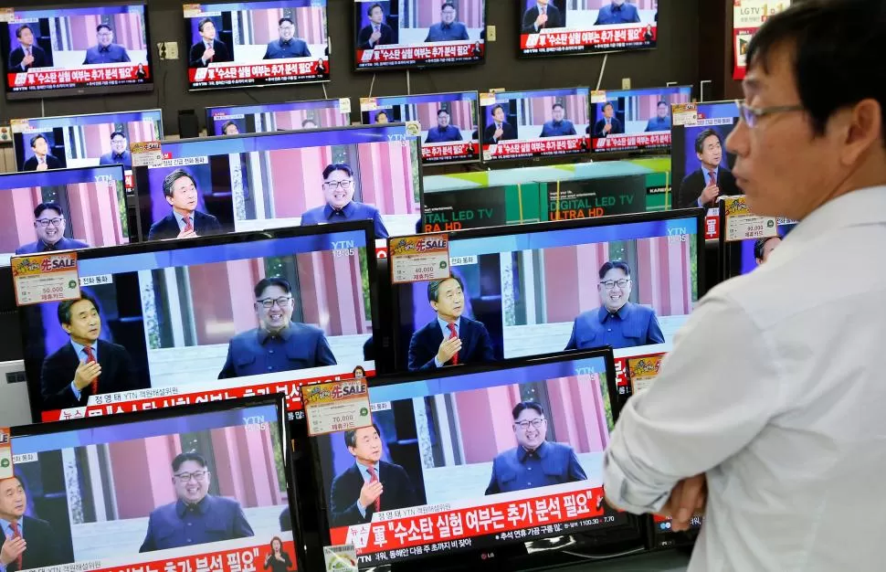 SORPRESA. Un asistente de ventas de televisores, en Corea del Sur, observa el mensaje que difundió Jong Un. reuters