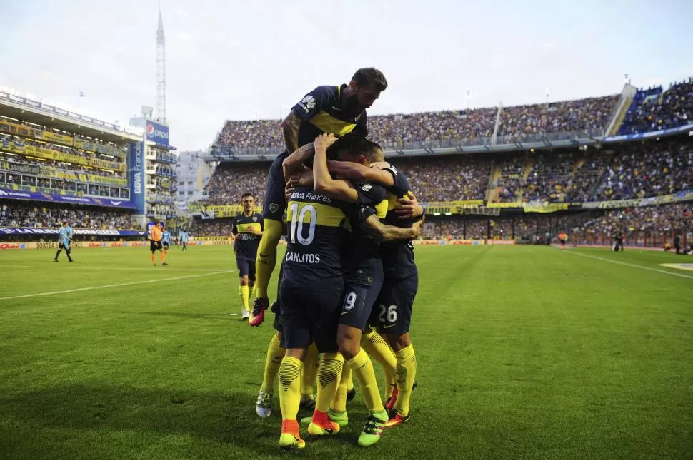 MONTAÑA DE ALEGRÍA. Los jugadores de Boca fueron en malón a buscar a Tevez (10), autor del 1-0 parcial ante Belgrano. télam