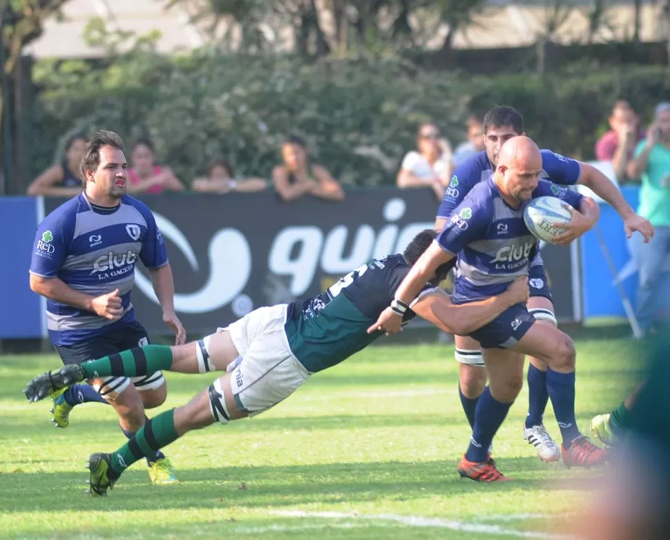 PELOTA EN MANO. Patricio Figueroa recibe el tackle de José María Young, seguido de cerca por Federico Gálvez. Universitario sufrió en el segundo tiempo, pero defendió hasta el final y tuvo su recompensa. la gaceta / foto de hector peralta