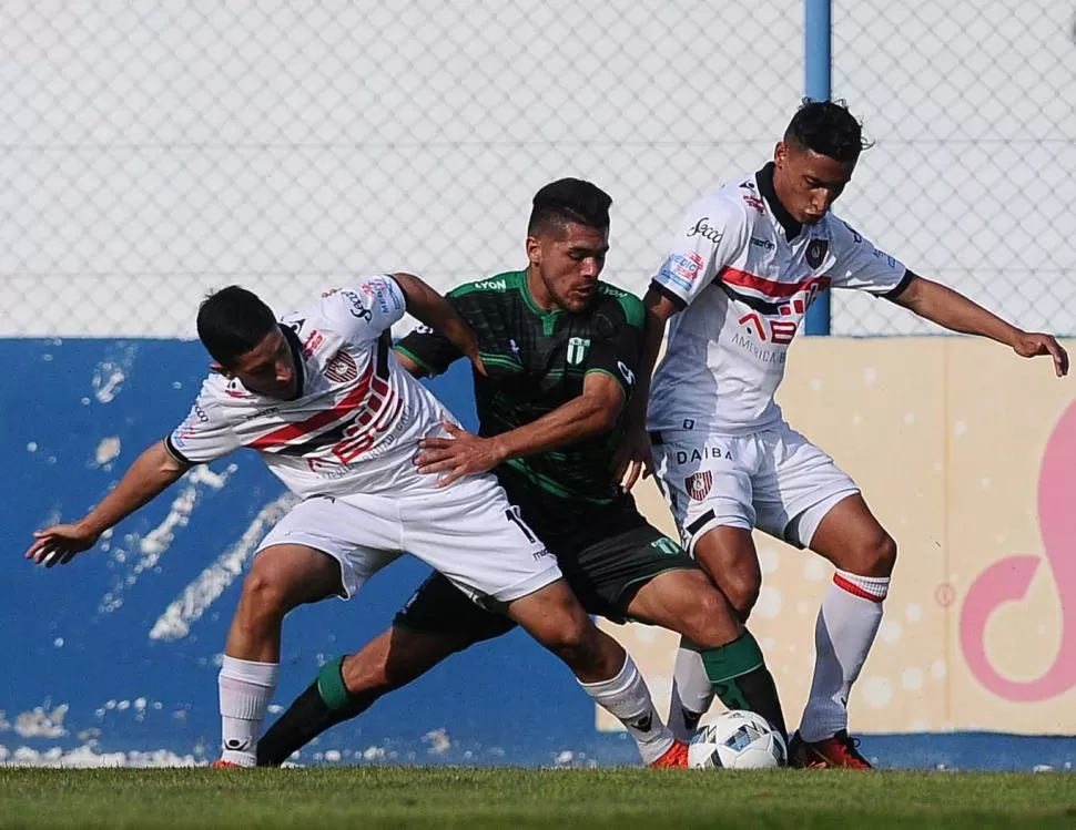 ENTRETENIDO. Un jugador de Estudiantes es marcado por dos de Chacarita. Hubo muchas ocasiones de gol, pero se tuvieron que conformar con el empate. télam