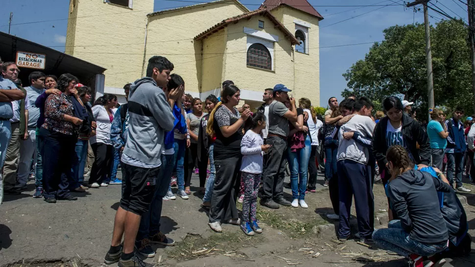 LA FLORIDA. Vecinos reunidos frente a la iglesia en la que apareció el cuerpo del sacerdote. LA GACETA / JORGE OLMOS SGROSSO