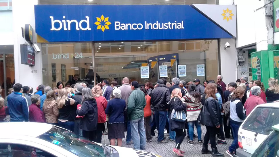 EN LA CALLE. Los bancos optaron por hacer ingresar de a poco a sus clientes así no quede gente dentro del salón cuando comience la asamblea. FOTO ENVIADA POR WHATSAPP