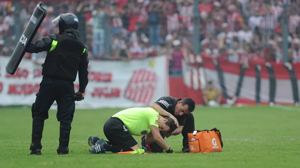 MAL MOMENTO. El juez de línea Martín Giampaolo es asistido dentro del campo de juego luego de la agresión sufrida. ARCHIVO LA GACETA / FOTO DE FRANCO VERA