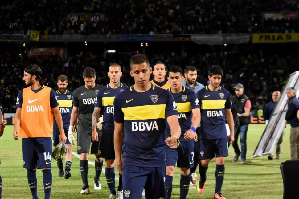 NO LO PUEDEN CREER. Fernando Tobio encabeza la salida de los de “Xeneizes” de la cancha, luego de la dura caída sufrida frente al “Canalla” en Córdoba. telam