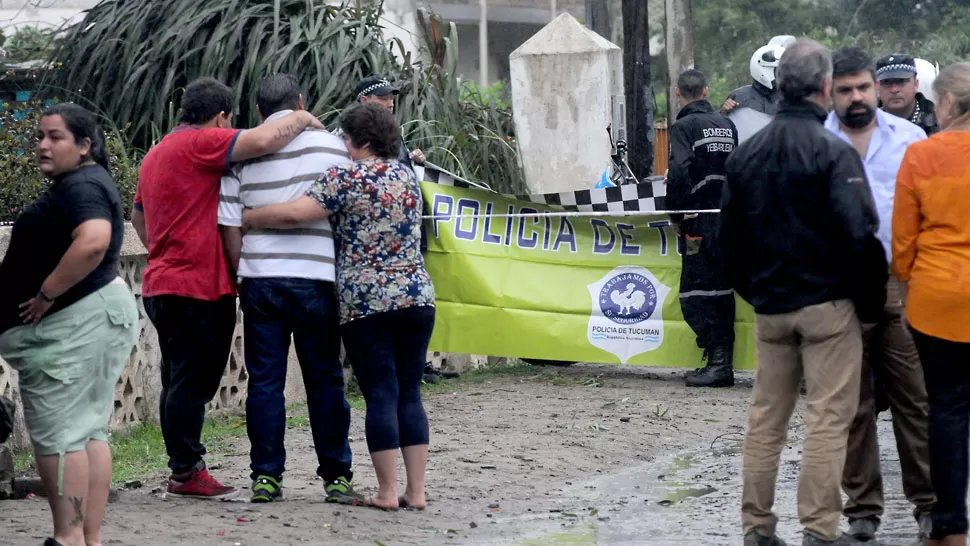 DOLOR INCONMENSURABLE. El padre de la víctima (de remera blanca rayada) es consolado por otras dos personas a metros de donde está el cuerpo de su hijo. LA GACETA / ANALÍA JARAMILLO 