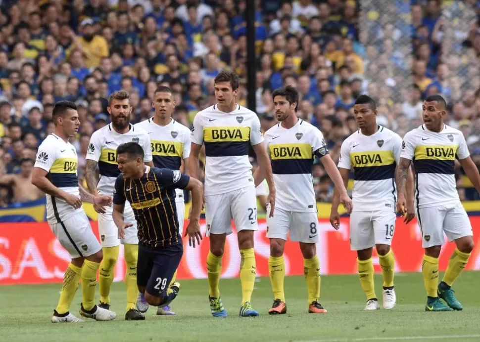 TODOS CONTRA “TEO”. Pavón, Peruzzi, Tobio, Vergini, Pérez, Fabra y Tevez rodean a Teófilo Gutiérrez quien acusa un golpe, luego de un festejo que significó su roja. dyn