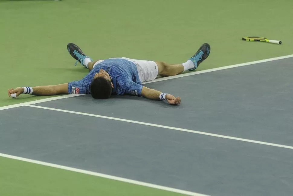 UN MOMENTO HISTÓRICO. Federico Delbonis ya ganó el último punto que le permitió derrotar a Ivo Karlovic y cae rendido antes que dar tienda suelta a los festejos. telam