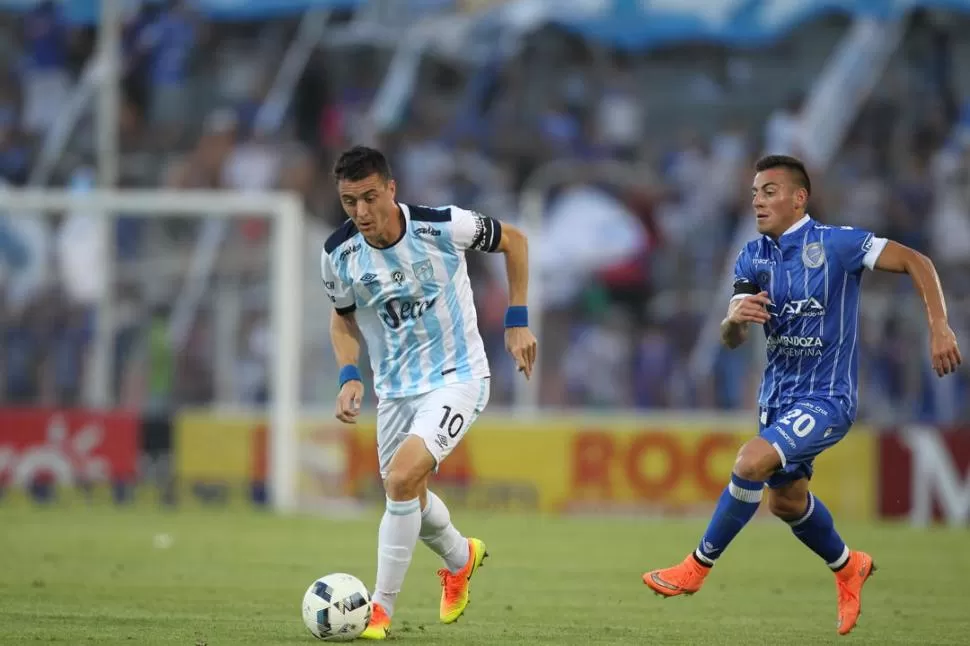 DUELO ENTRE DOS GONZÁLEZ. Leandro, de Atlético, se lleva la pelota ante la marca tardía de Ángel, de Godoy Cruz, durante el primer tiempo del partido de anoche. foto de marcelo ruiz (especial para la gaceta)