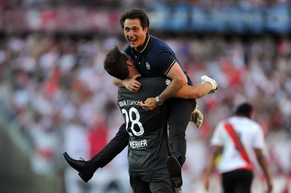 FESTEJO. Guillermo Barros Schelotto abraza al arquero Werner tras el 4-2. El DT vivió el duelo de manera intensa. telam